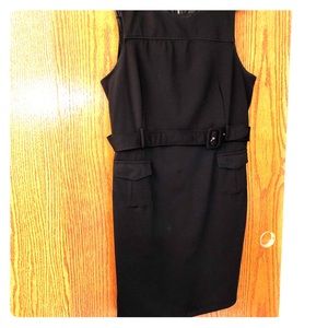 Women’s belted black dress with pockets.